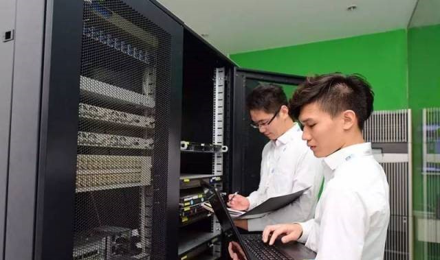 云计算运维工程师在数据中心机房内巡检服务器设备工作照