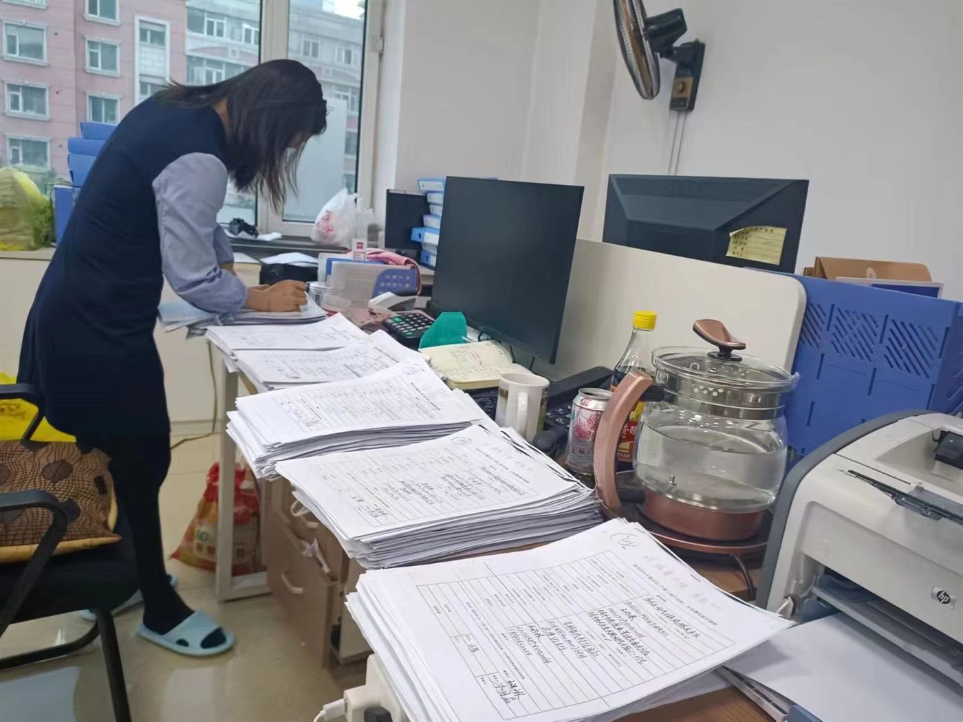 办公桌上成摞的登记表格与审批资料实拍照片