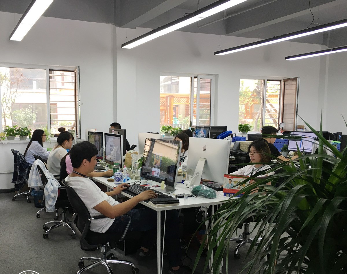 企业开放式办公区员工使用电脑工作实拍照片